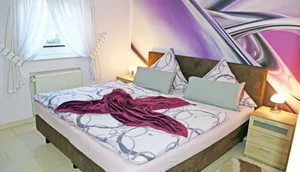 Schlafzimmer mit Boxspringbett und Nachttischen